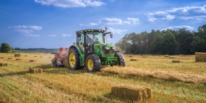 Tractor harvesting hay in field